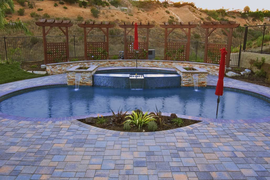 A large swimming pool with a waterfall in the middle of it