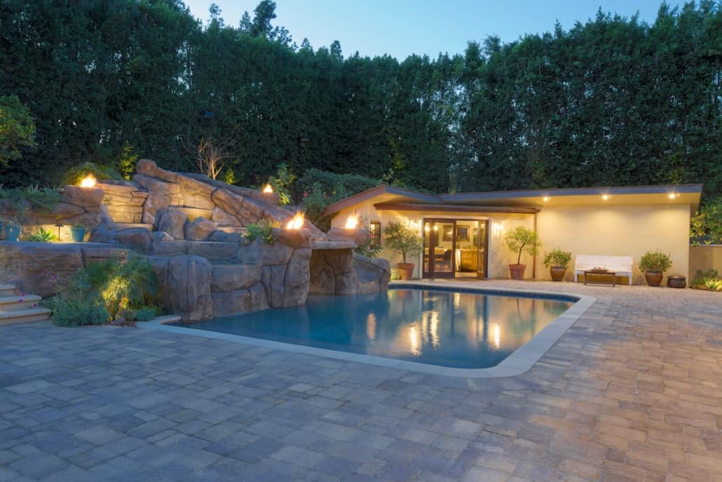A house with a large swimming pool in front of it