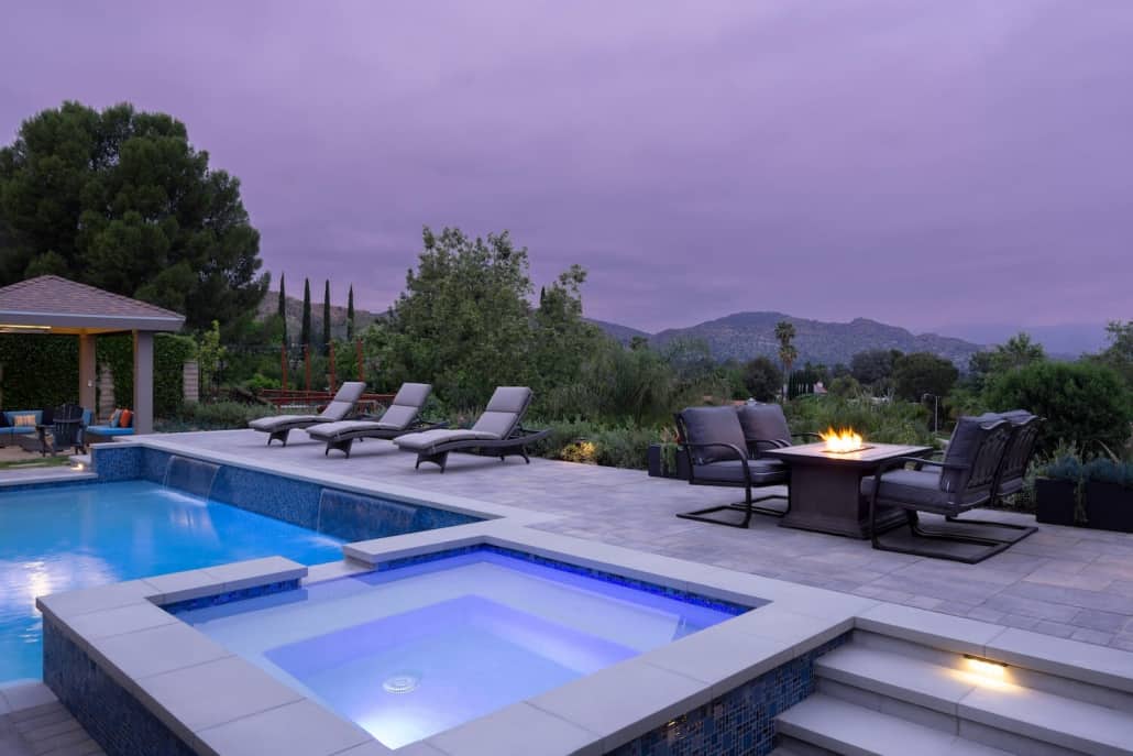 There is a large swimming pool with a hot tub in the middle of it.