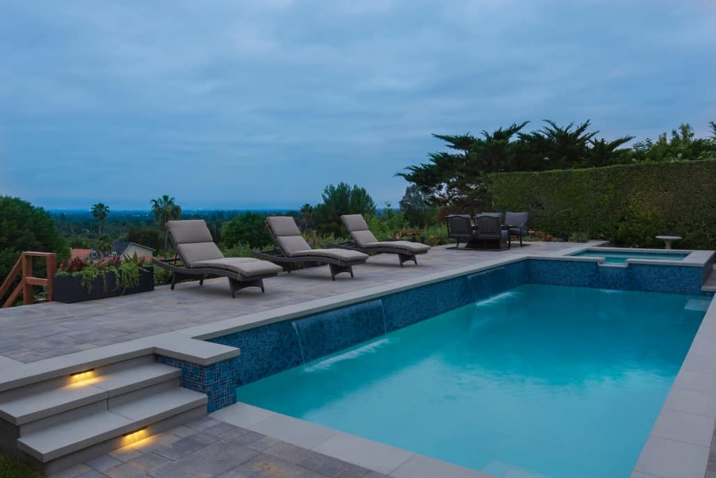 A large swimming pool with lounge chairs around it