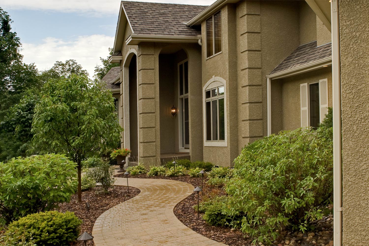 A large house with a walkway leading to the front door.