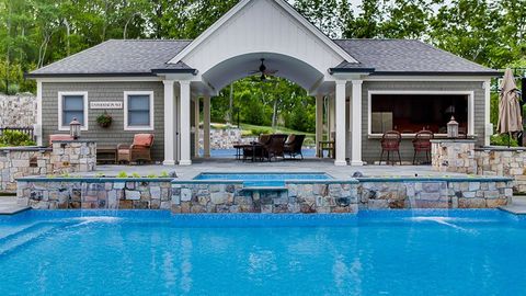 A large house with a swimming pool in front of it.
