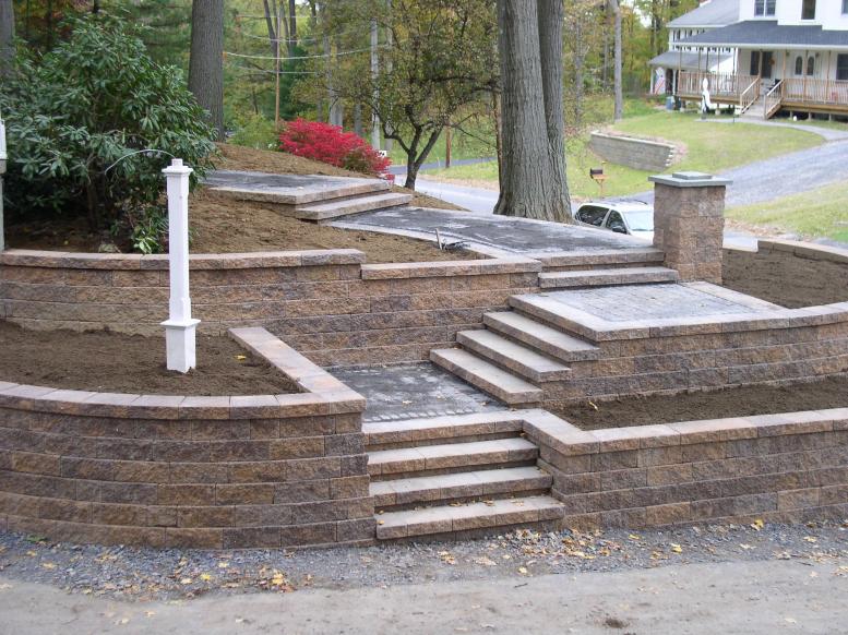 A brick wall with stairs leading up to a house.