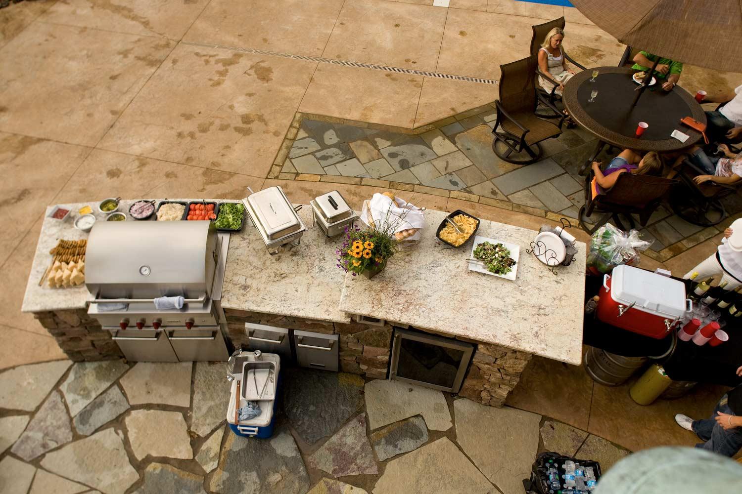 An aerial view of a patio with tables and chairs and a grill.