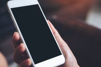 Hand holding white mobile phone