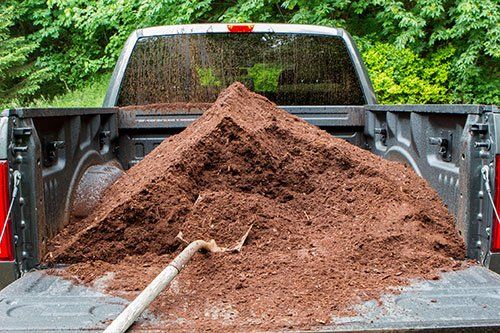 heap of mulch in bed of pickup truck