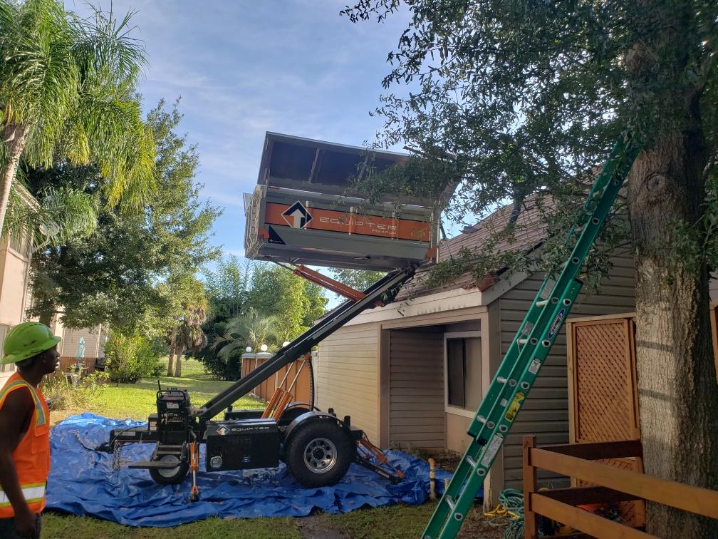 a man is standing next to a ladder in front of a house .