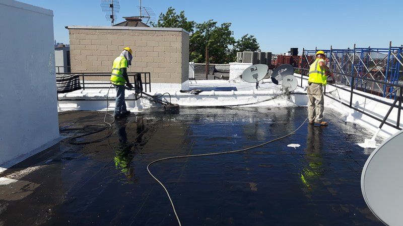Roofing contractors spraying down roof 