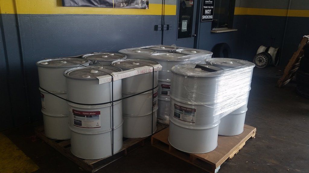 a bunch of barrels are stacked on top of each other on a pallet in a garage .