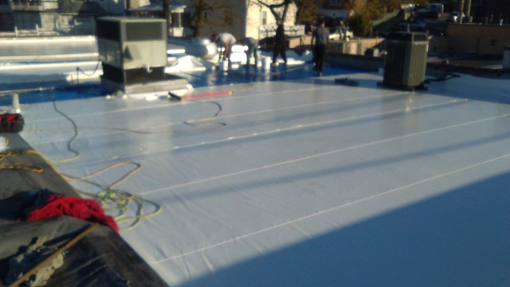 a white roof is being installed on a building .