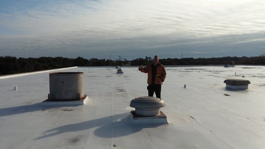a man is standing on top of a white roof .