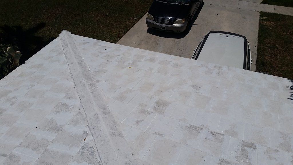 a car is parked in a driveway next to a white roof .