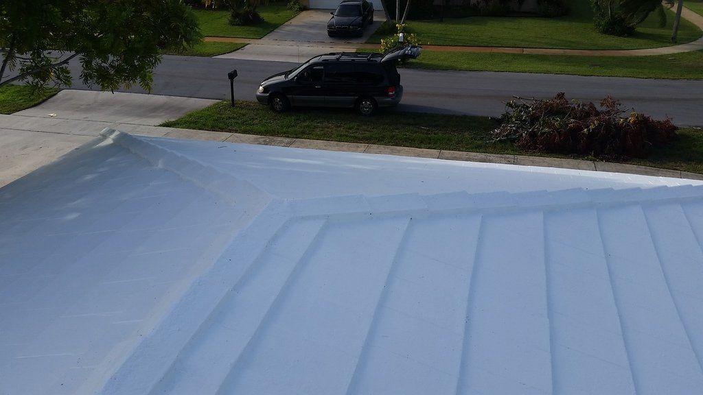 a car is parked on the side of the road next to a roof .