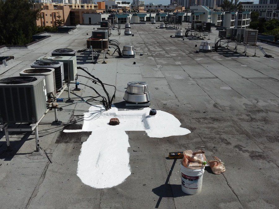 a bucket of white paint sits on the roof of a building