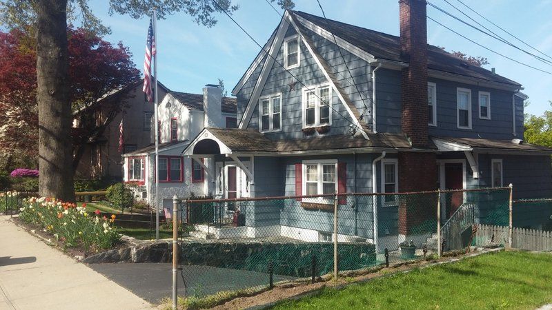 a house with a fence around it and an american flag in front of it