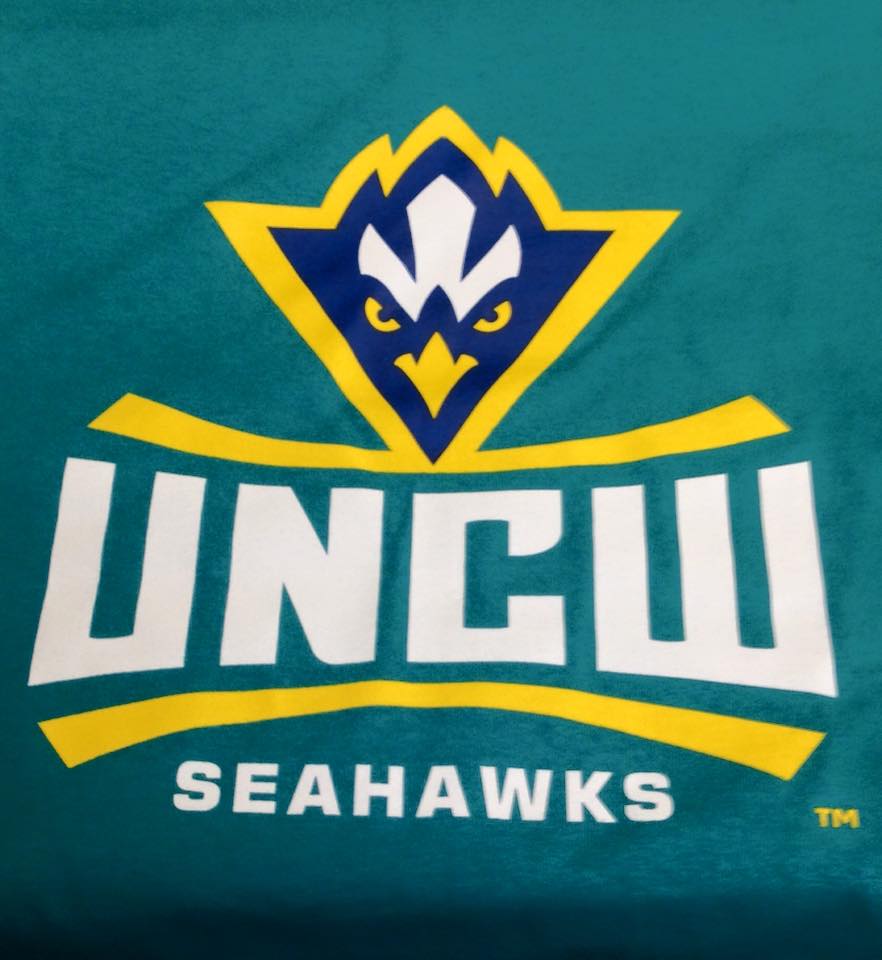 UNCW Seahawks logo on teal background: a yellow-outlined diamond and text with a blue and white eagle head.