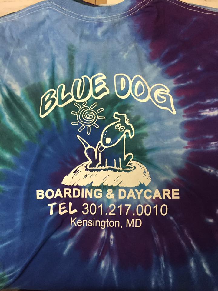 Blue Dog Boarding & Daycare logo on a blue tie-dye shirt. Features a cartoon dog and the business's contact info.
