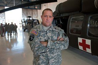 MG David Baldwin - Photo Credit: SacBee A man in a military uniform is standing in front of a helicopter with his arms crossed.