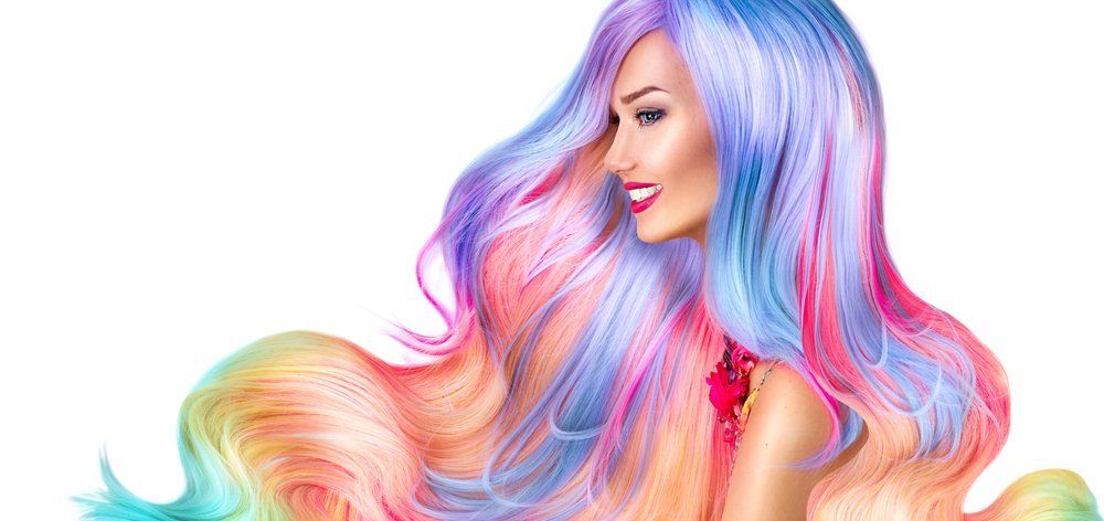 Eine Frau mit langen bunten Haaren sitzt auf einem weißen Hintergrund.