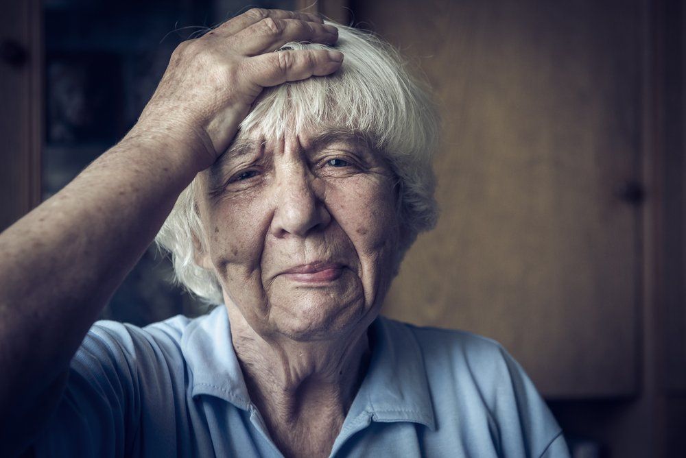 woman holding head after suffering stroke