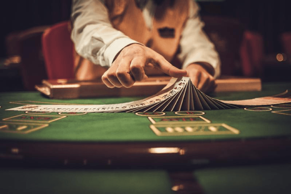 A man is playing cards at a table in a casino.