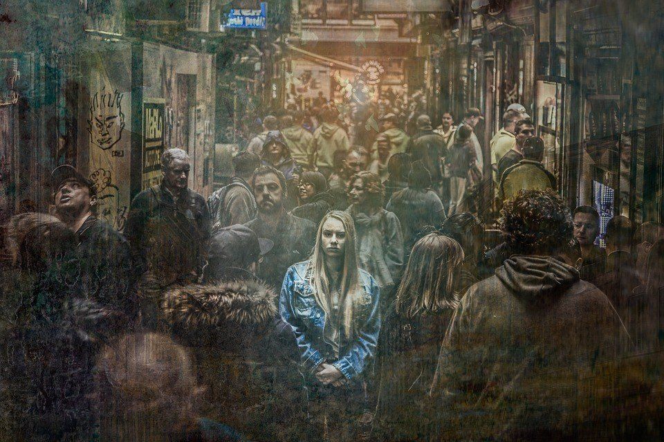 A woman is standing in the middle of a crowd of people.