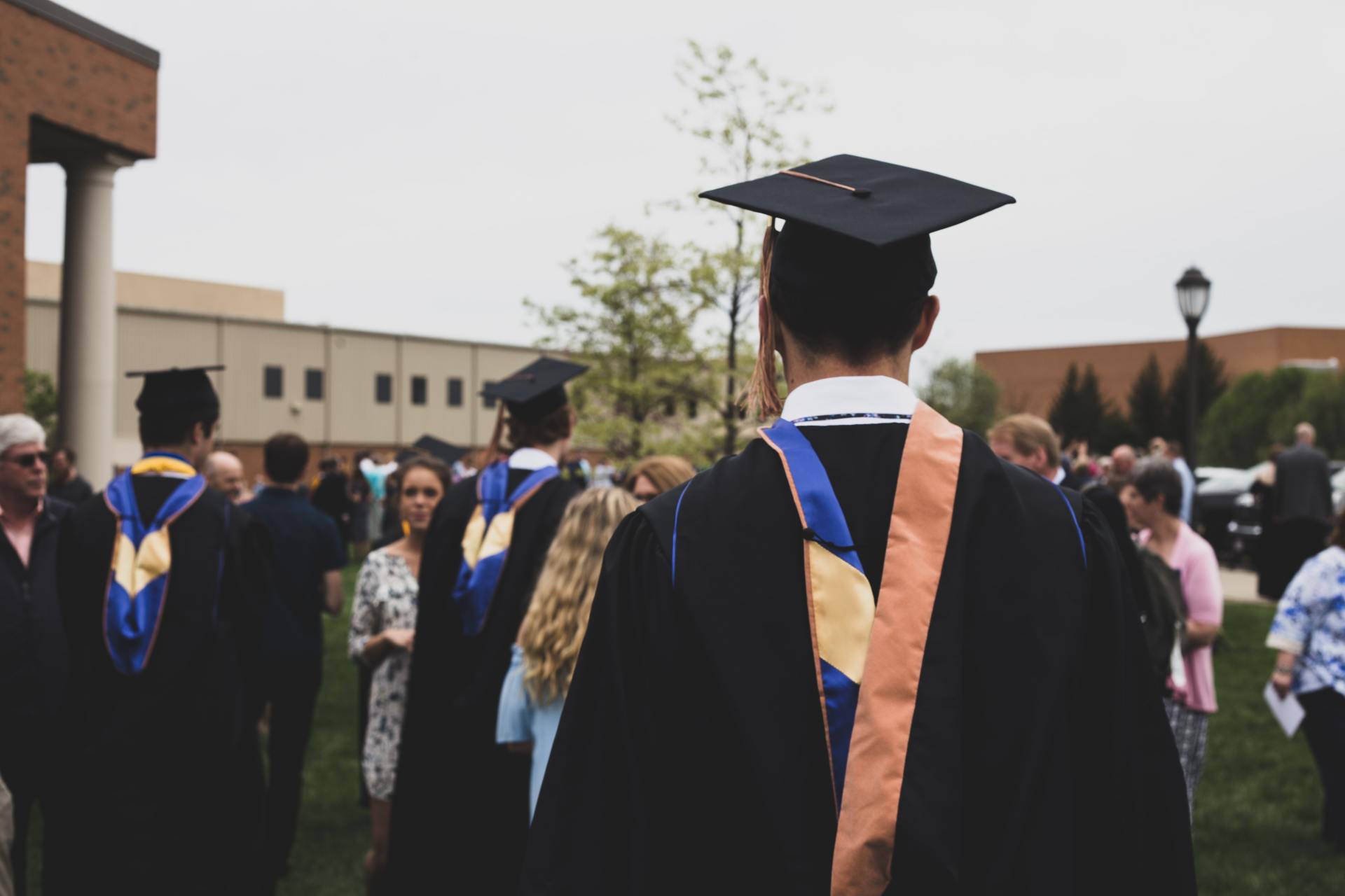 A group of graduates are standing in front of a building.