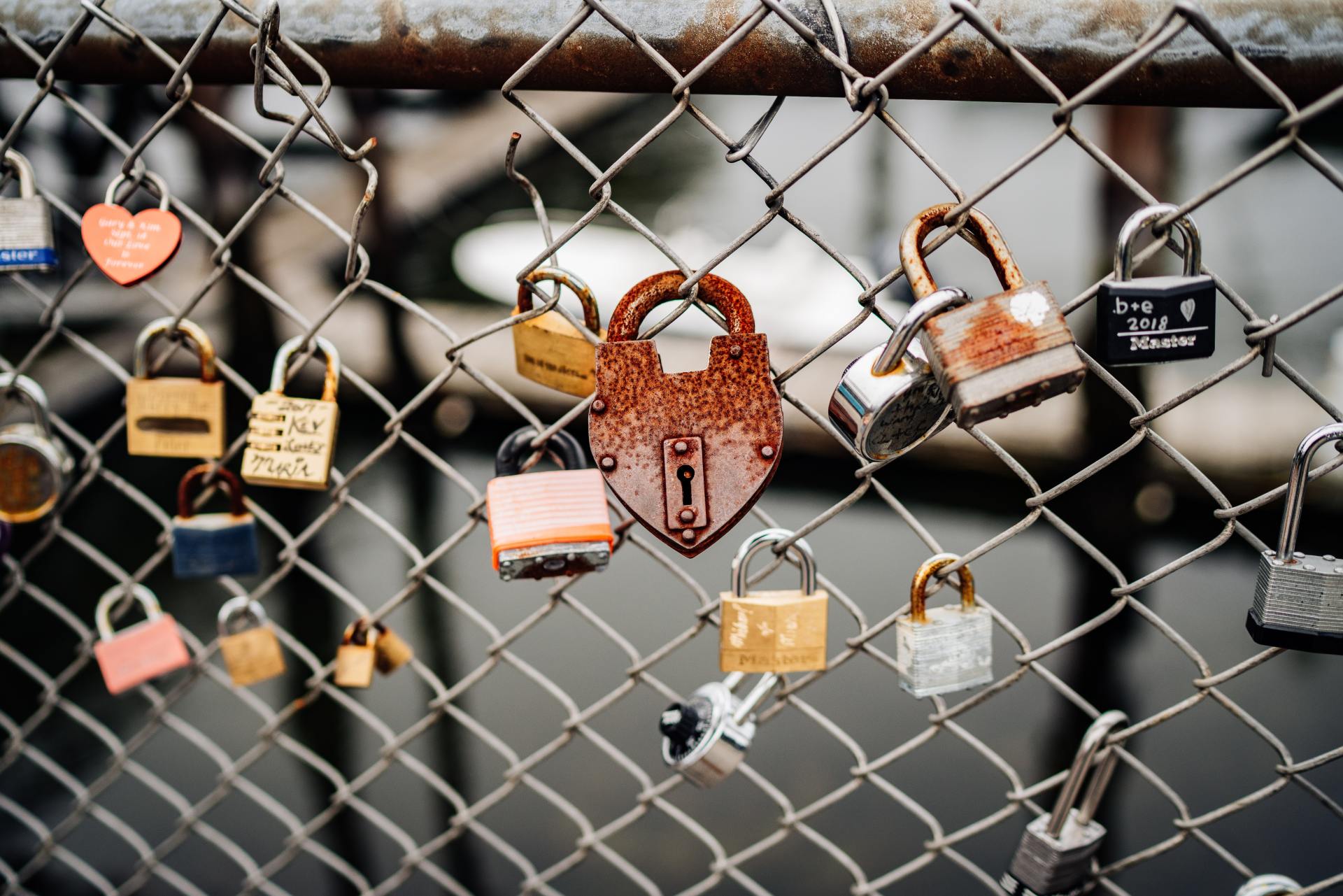 A chain link fence with lots of padlocks hanging from it.