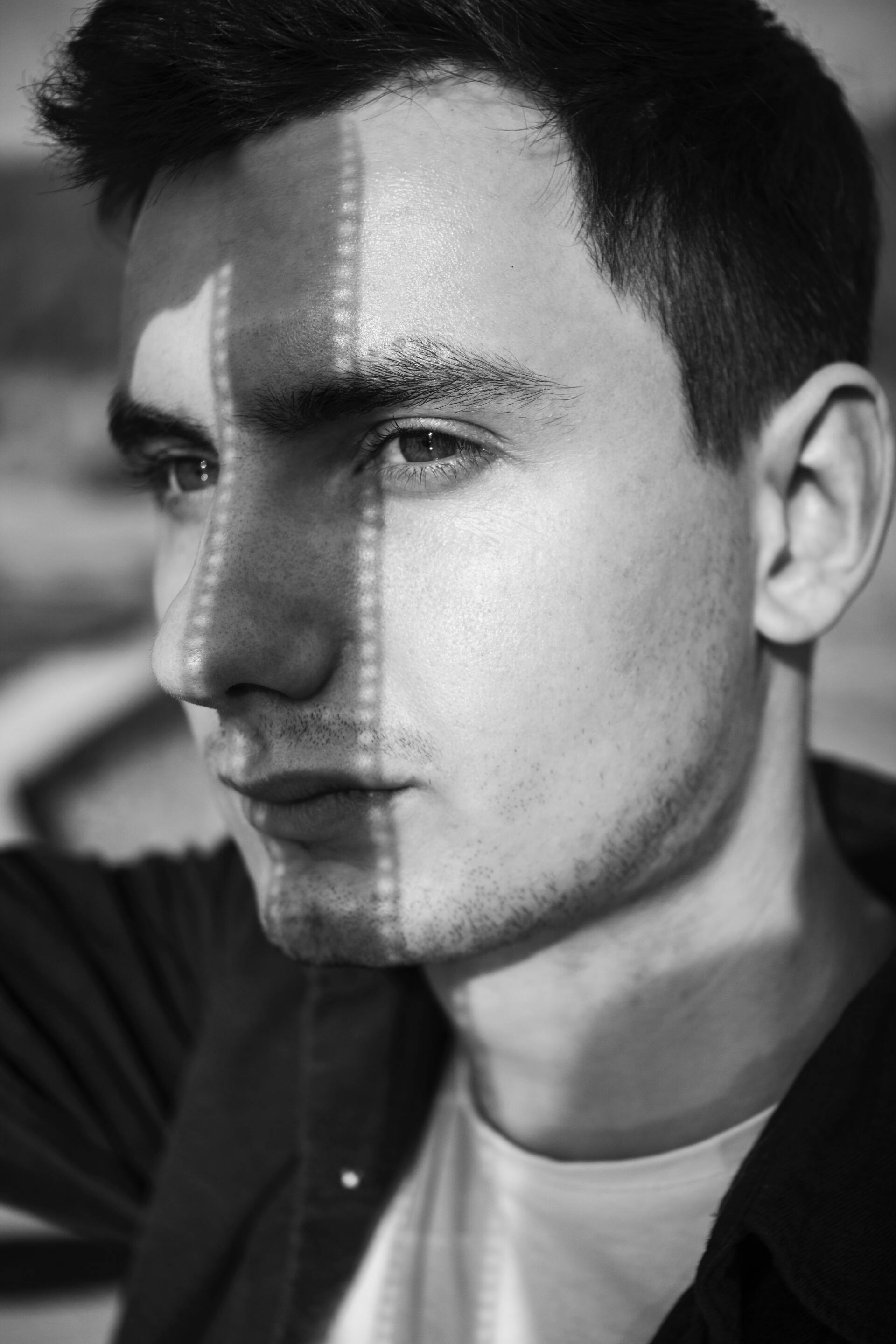A black and white photo of a man with a shadow on his face.