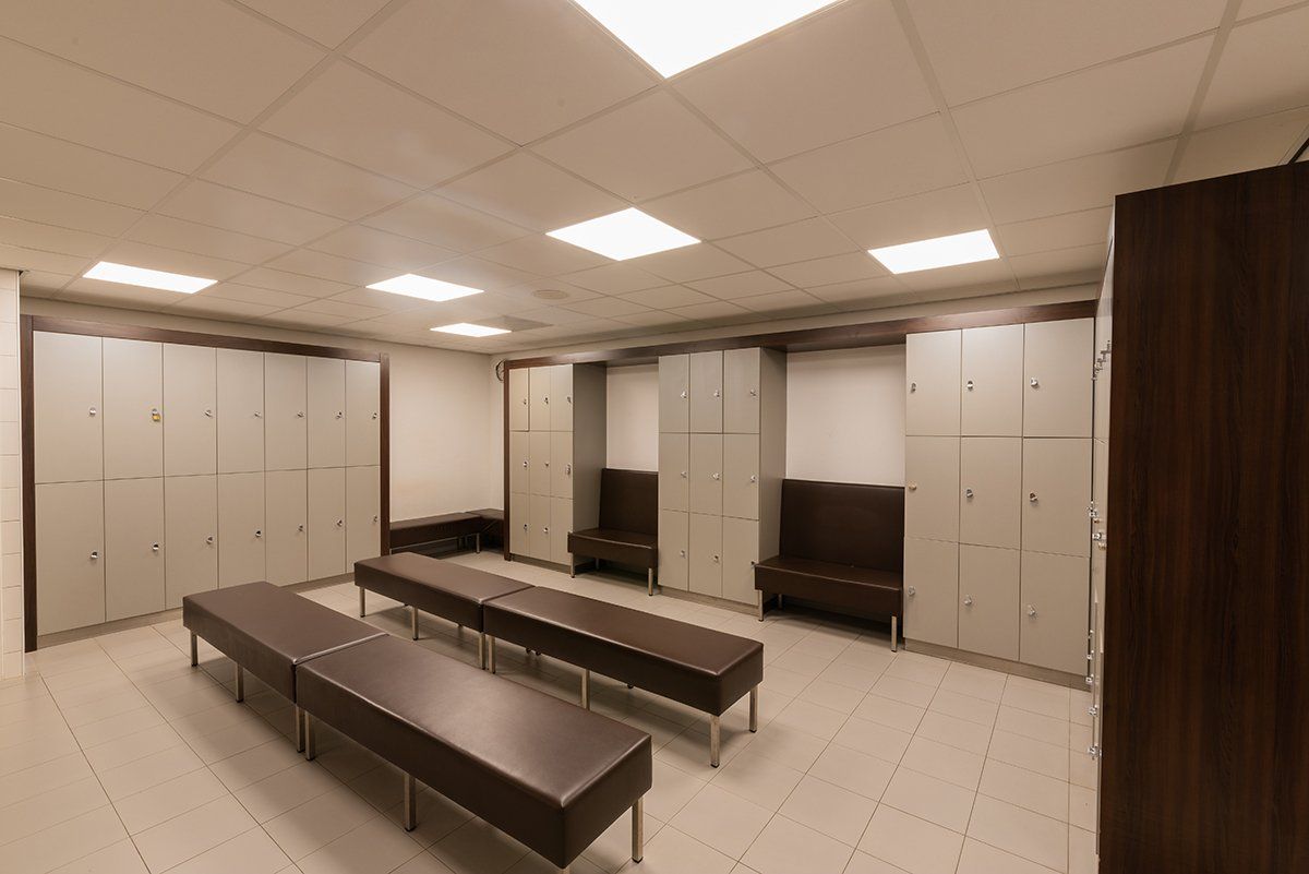 Een kleedkamer met veel kluisjes en bankjes
