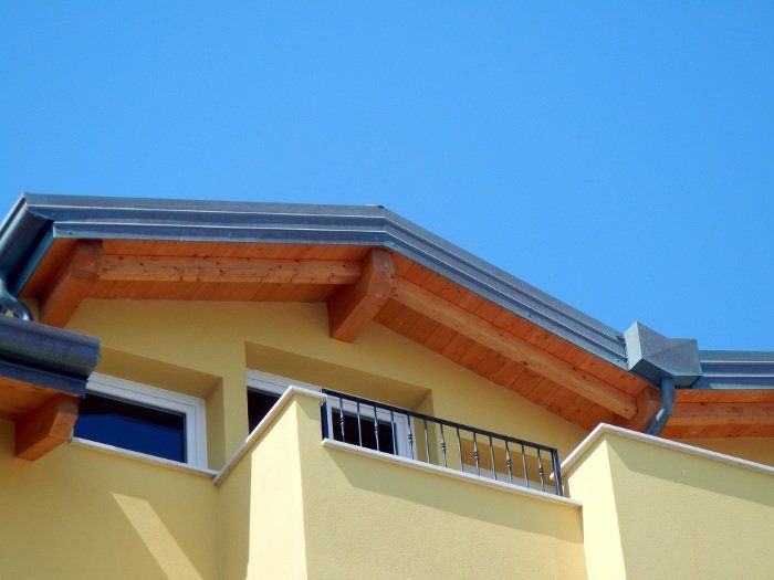 Un edificio giallo con un balcone e un cielo azzurro sullo sfondo
