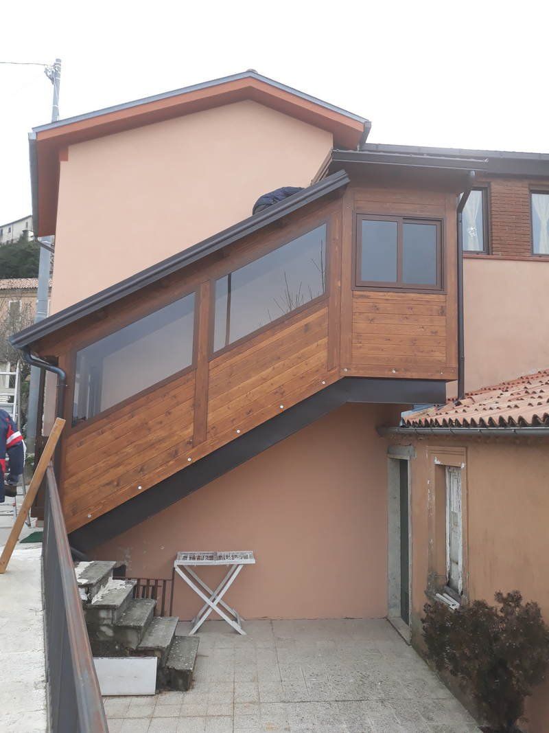 Una casa con una scala di legno che porta al secondo piano