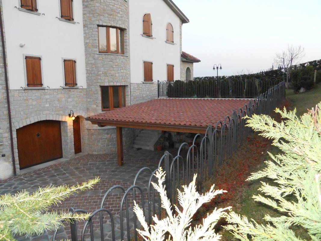 Una casa bianca con il tetto rosso e una recinzione intorno