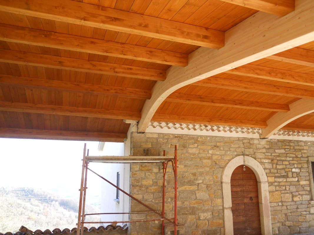 Un edificio in pietra con un tetto in legno e un'impalcatura di fronte