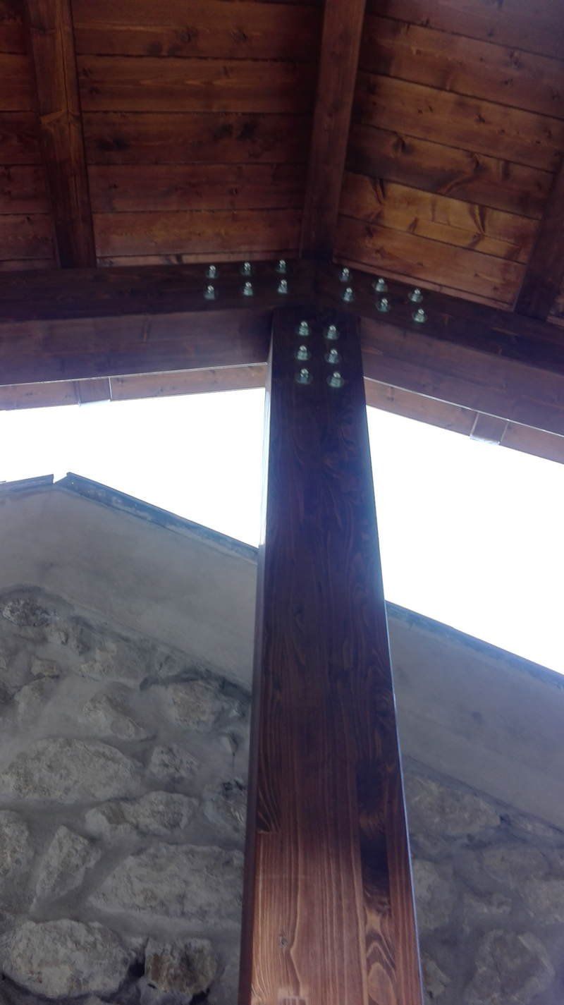 Un primo piano di un palo di legno sotto un tetto