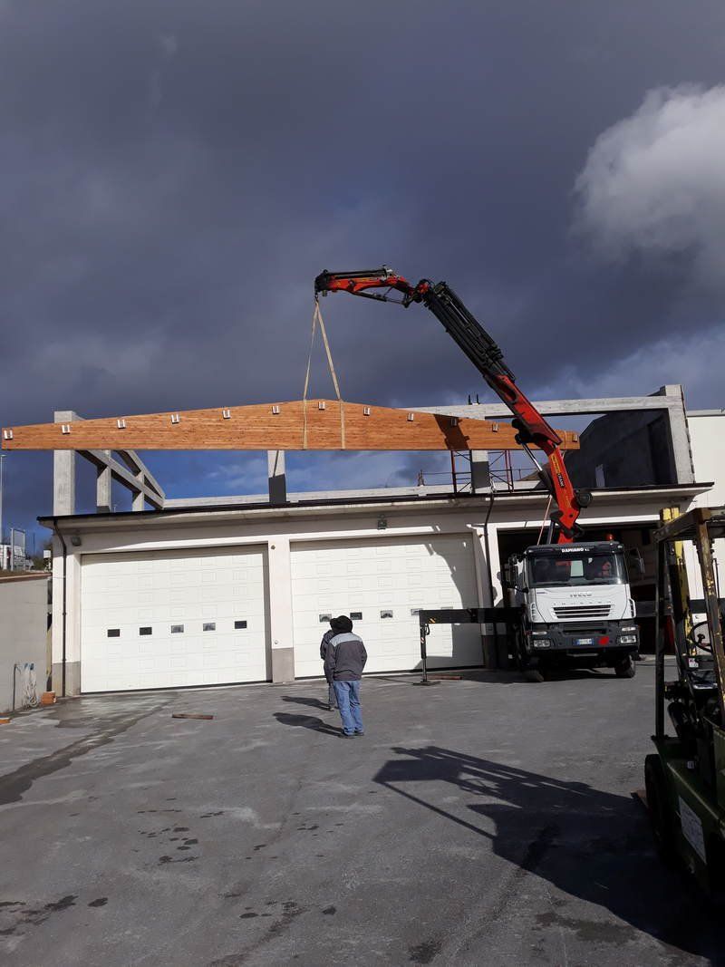 Una gru sta sollevando un pezzo di legno in un edificio