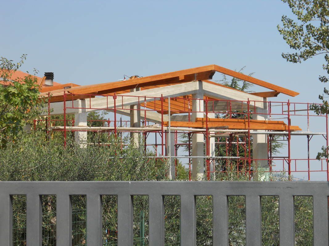 Una casa in costruzione con una recinzione in primo piano