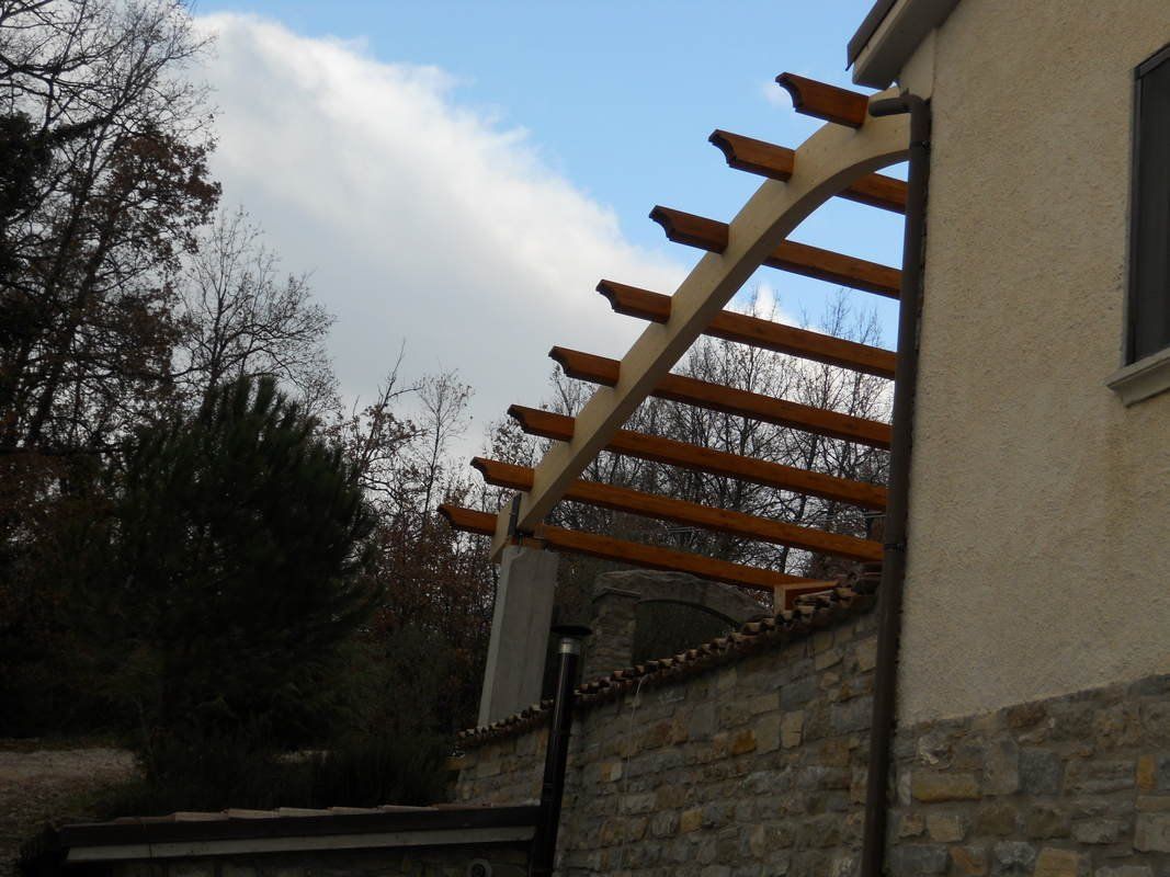 Un edificio con un pergolato di legno in cima