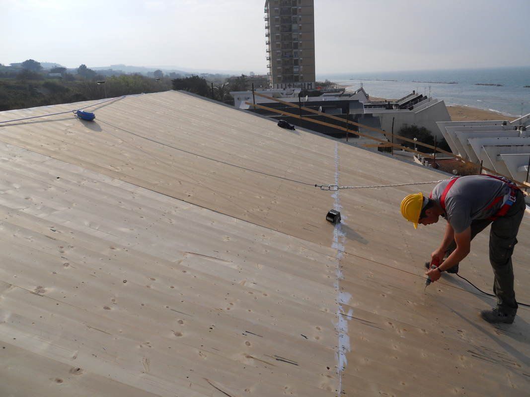 Un uomo sta lavorando sul tetto di un edificio