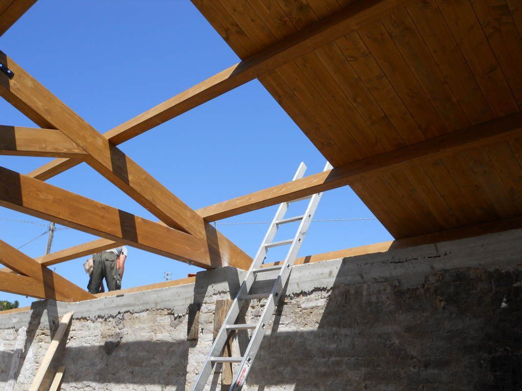 Un uomo in piedi in cima a una struttura di legno con una scala