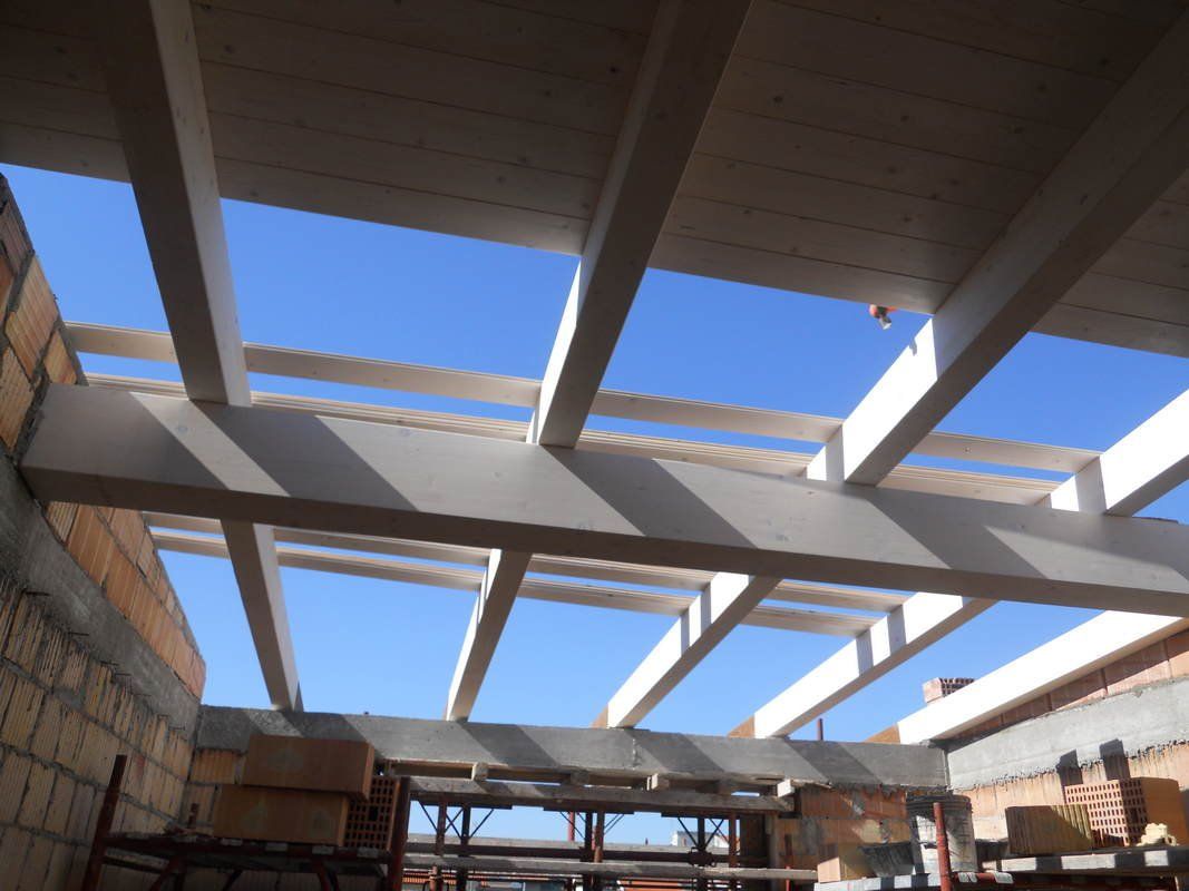 Un soffitto con travi bianche e un cielo azzurro sullo sfondo