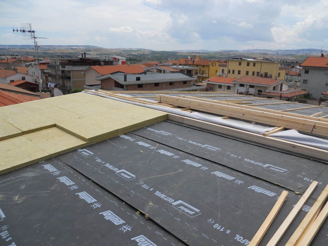 Si sta costruendo un tetto con la vista di una città sullo sfondo.