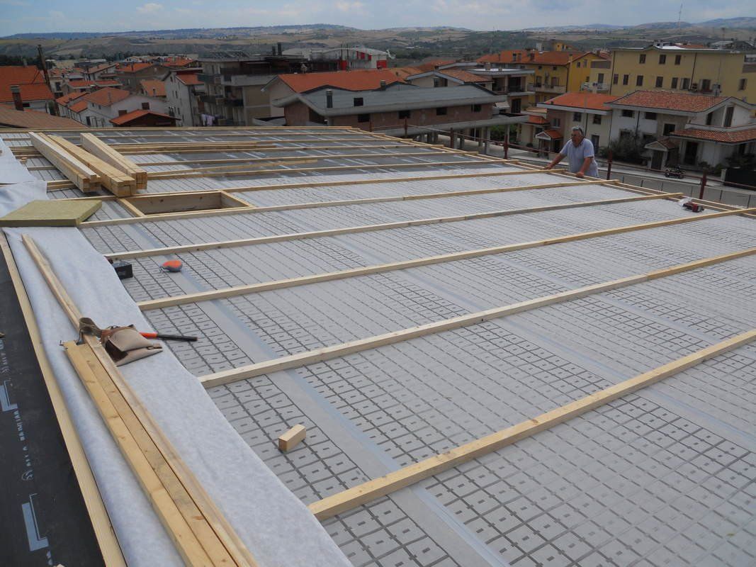 Un uomo sta lavorando sul tetto di un edificio