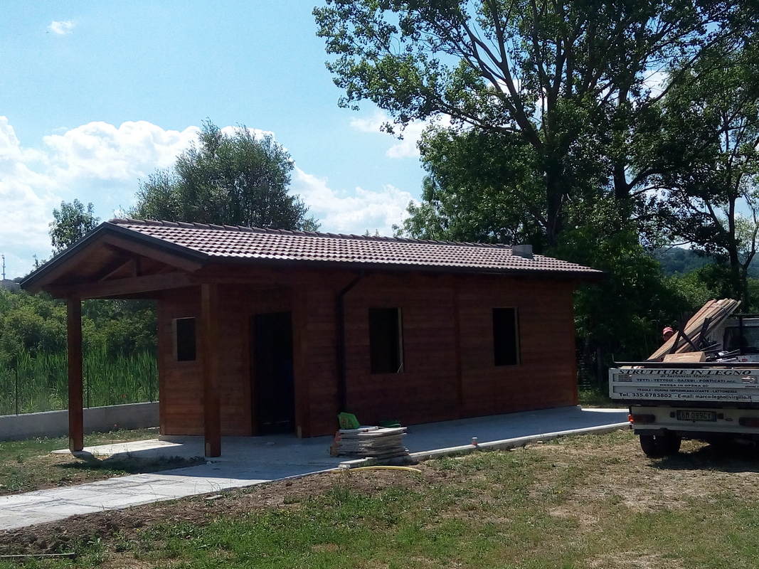 Un camion è parcheggiato davanti a una piccola casa di legno.