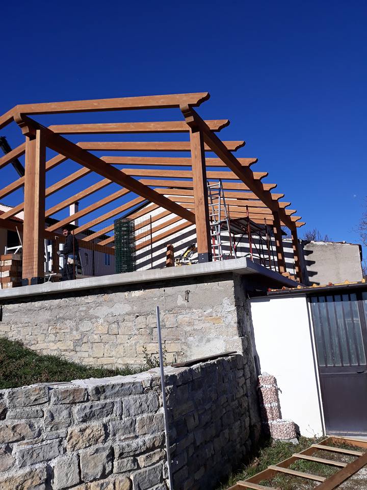 Una struttura in legno viene costruita sopra un muro di pietra