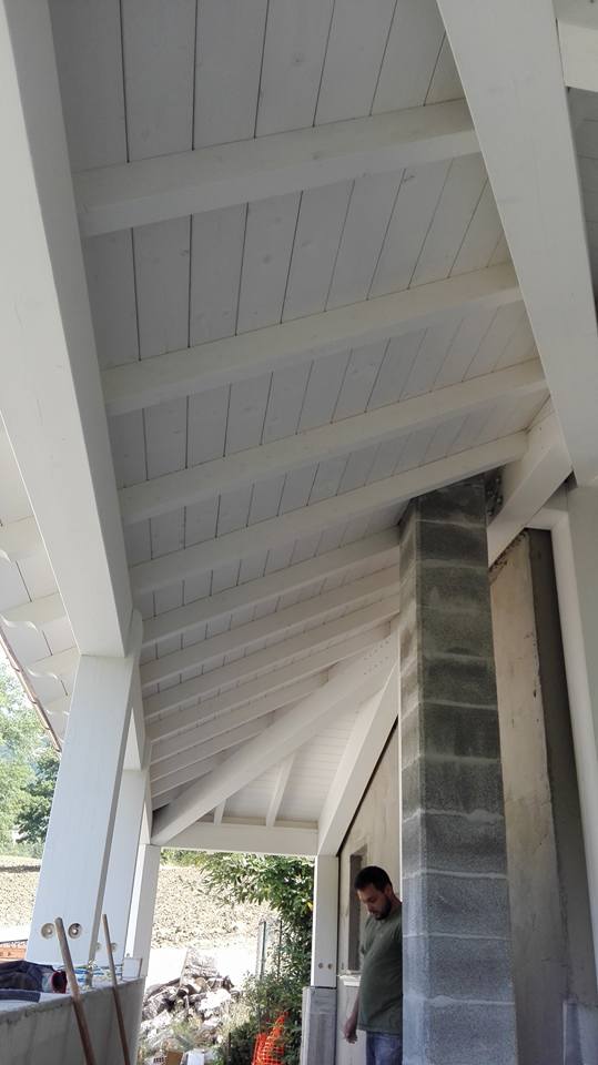 Un uomo è in piedi sotto un tetto di legno bianco.