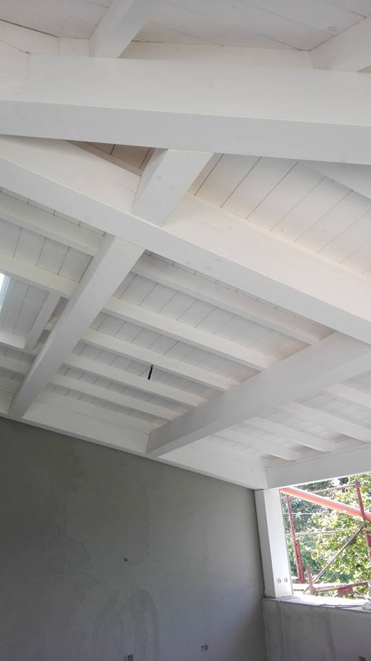 Una stanza con un soffitto bianco e una finestra.