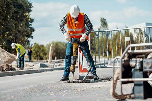 Paving — Worker In Reflective Vest With Drill in Colorado Springs, CO