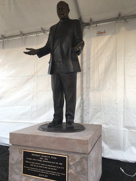 A statue of a man standing in front of a white tent
