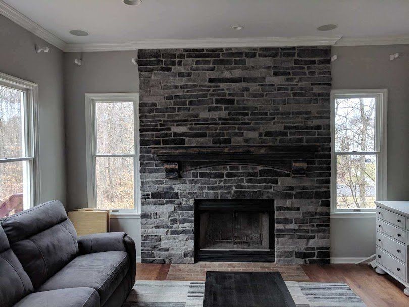 A living room with a brick fireplace and a couch